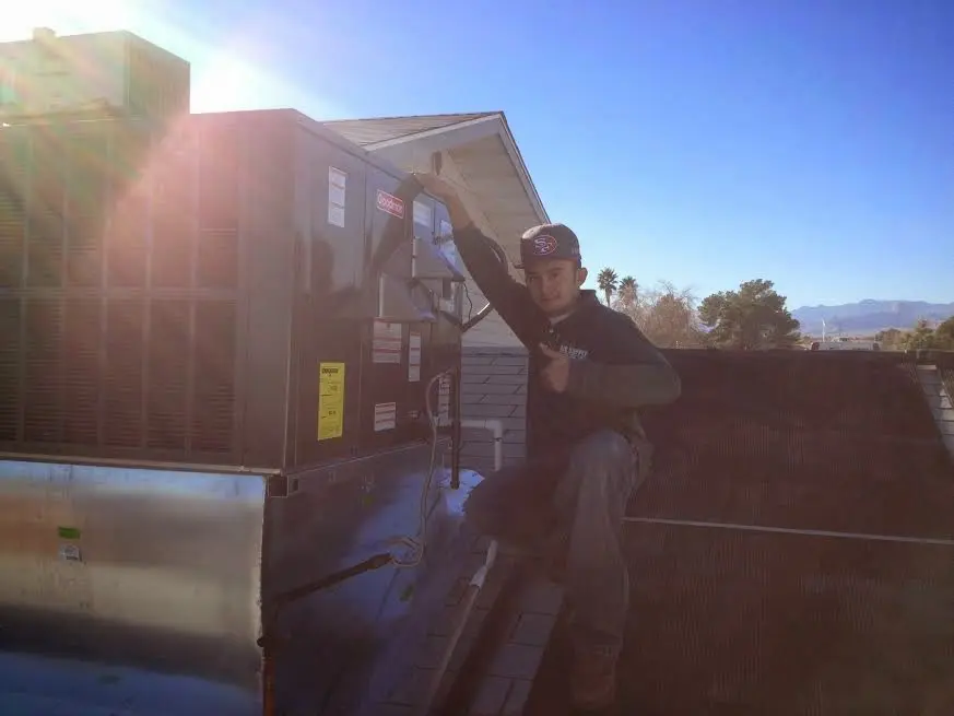 HVAC technician performing Boiler Repair on a rooftop unit in Carnegie